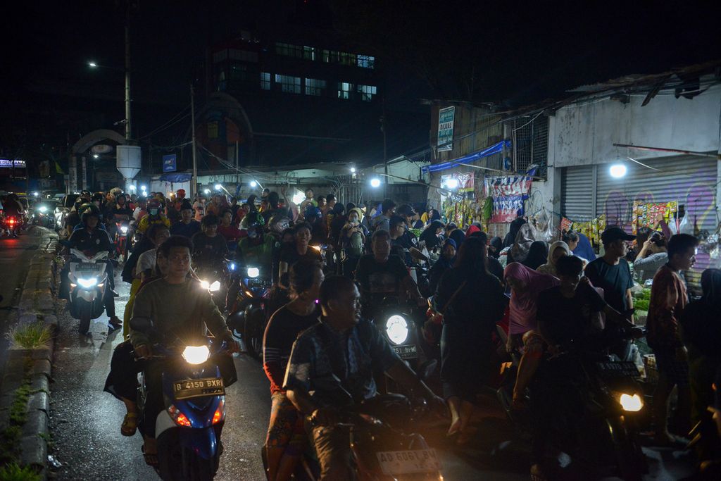 Sejumlah pengendara sepeda motor terjebak macet saat melintasi pasar tumpah di Jalan Palmerah Barat, Jakarta Pusat, Rabu (22/3/2023). Menjelang Ramadhan 1444 Hijriah, warga berbondong-bondong berbelanja kebutuhan untuk sahur pertama. Keramaian tersebut terlihat di pasar tumpah di Jalan Palmerah Barat pada pukul 21.00. Walaupun harga kebutuhan pokok mulai merangkak naik, warga tetap semangat menyambut Ramadhan dengan menyajikan masakan terbaik untuk sahur pertama.