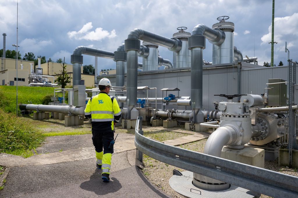 Foto yang diambil per 10 Juni 2022 ini menunjukkan seorang pekerja Uniper Energy Storage berjalan melewati fasilitas penyimpanan gas di Bierwang, Jerman. (Photo by LENNART PREISS/AFP)