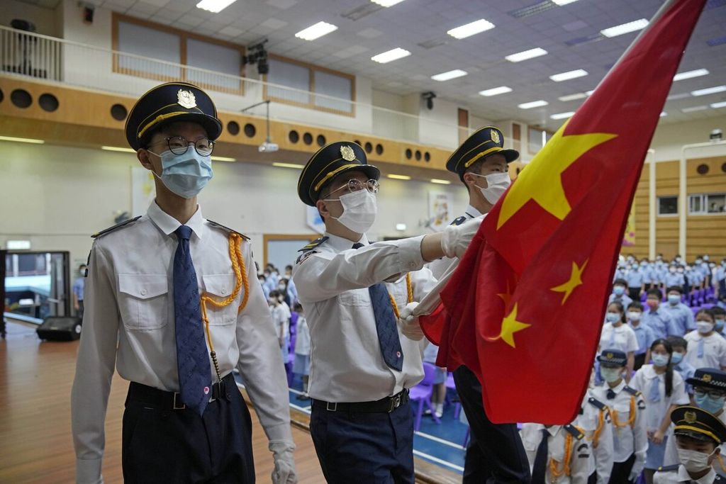 Para siswa dengan tetap memakai masker untuk membantu mencegah penyebaran virus korona baru menghadiri upacara pengibaran bendera nasional China pada hari pertama tahun ajaran baru di salah satu sekolah menengah, di Hong Kong, Rabu (1/9/2021).