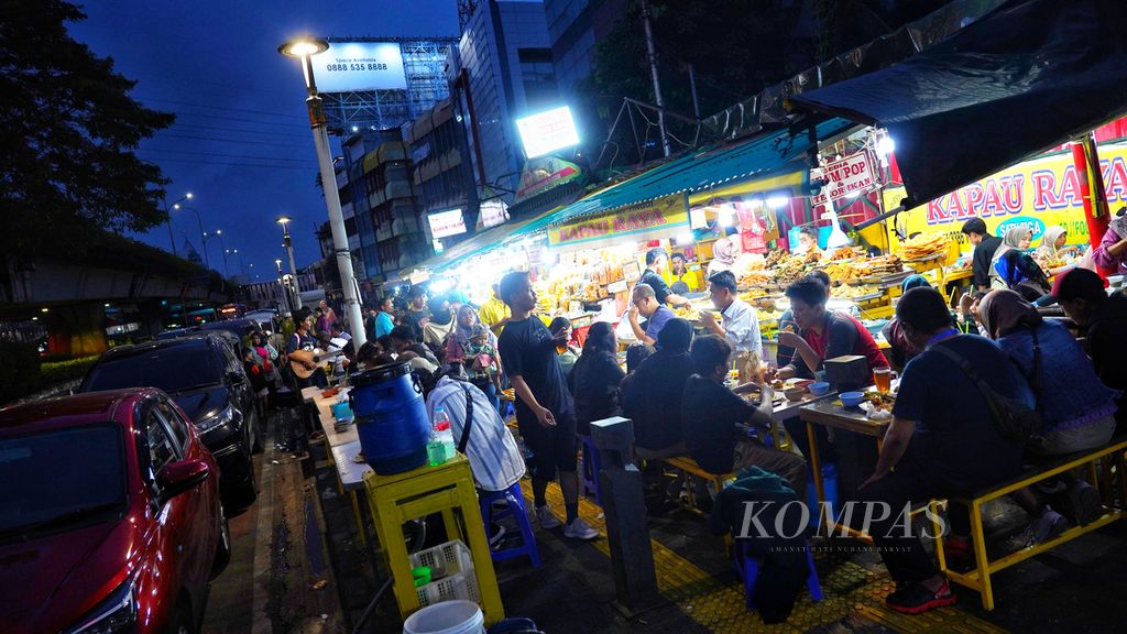 Suasana saat warga berbuka puasa di lapak pedagang nasi kapau di Senen, Jakarta Pusat, Rabu (13/3/2024). Salah satu sentra kuliner nasi kapau di Senen menjadi pilihan warga untuk melakukan buka puasa. 