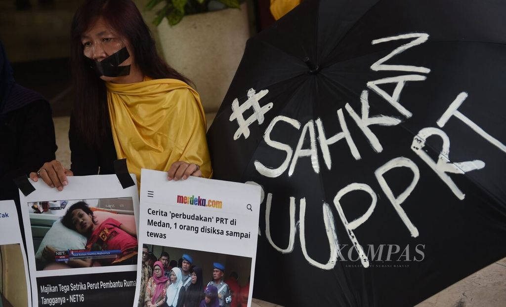 Dengan membawa poster dan menutup mulut, Aktivis Rampak Sarinah melakukan aksi simpatik dalam rangka Hari Pekerja Rumah Tangga (PRT) Nasional di Depan DPRD Surabaya, Jawa Timur, 