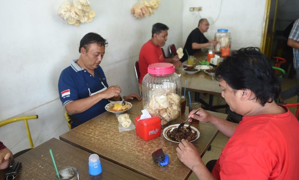 Pengunjung menyantap rawon balungan Benowo H Mufid saat jam makan siang di Surabaya, Jawa Timur, Rabu (13/9/2023). Usaha rawon balungan tersebut berdiri sejak tahun 1965. 