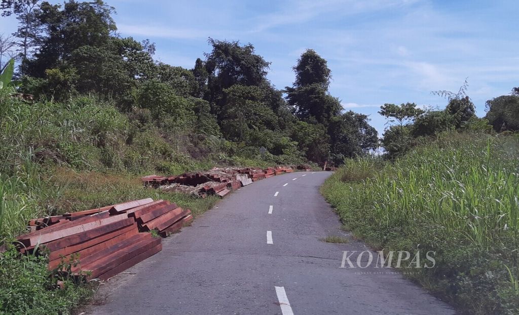 Kondisi sejumlah ruas jalan di Kabupaten Keerom, Papua. Tampak puluhan kayu merbau yang dijual warga di pinggiran jalan.