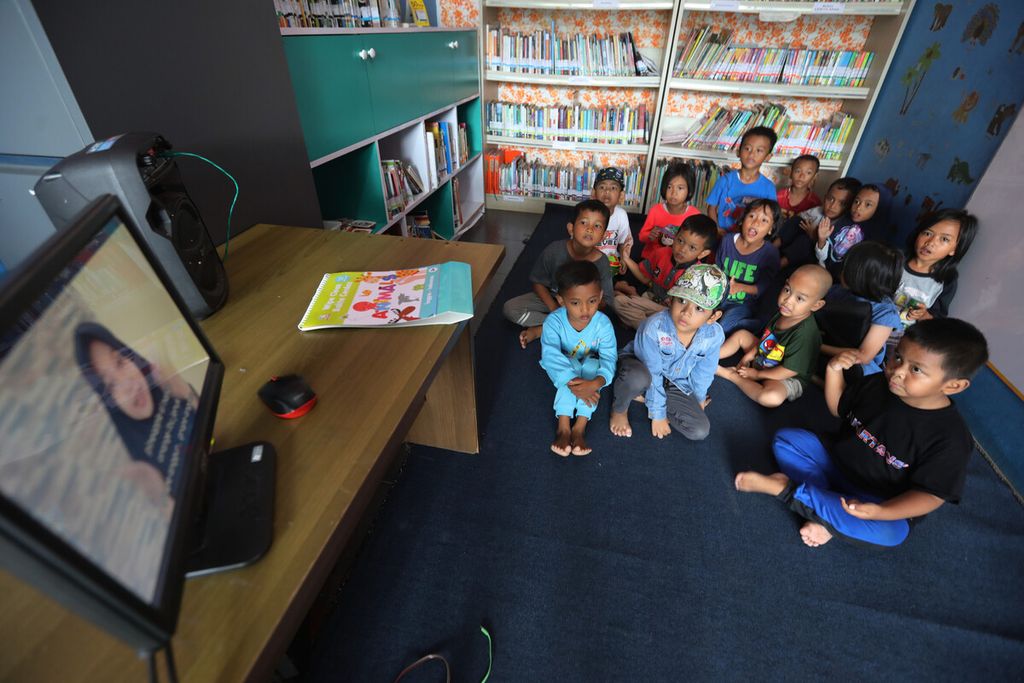 Anak-anak peserta sesi pengenalan bahasa Inggris menyimak sajian video di RPTRA Malinjo, Pasar Minggu, Pejaten Barat, Jakarta Selatan, Rabu (8/2/2023). RPTRA ini memberikan kursus gratis bagi anak-anak waga sekitar yang dibimbing  pengelola.
