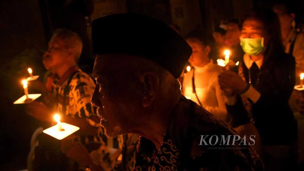 Warga dari berbagai latar belakang keyakinan berdoa bersama dengan menyalakan lilin saat berlangsung Refleksi Peristiwa Iman 13 Mei 2018 di Gereja Katolik Santa Maria Tak Bercela, Surabaya, Senin (13/5/2019). 
