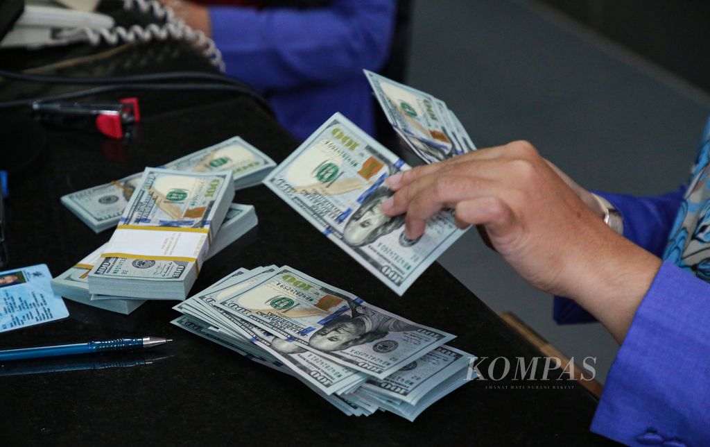 Petugas memeriksa kondisi uang dollar Amerika Serikat (AS) yang ditukarkan nasabah di tempat penukaran valuta asing PT Valuta Inti Prima di Jakarta, Senin (3/10/2022). Kondisi uang dollar AS yang ditukarkan berpengaruh pada nilai tukar.
