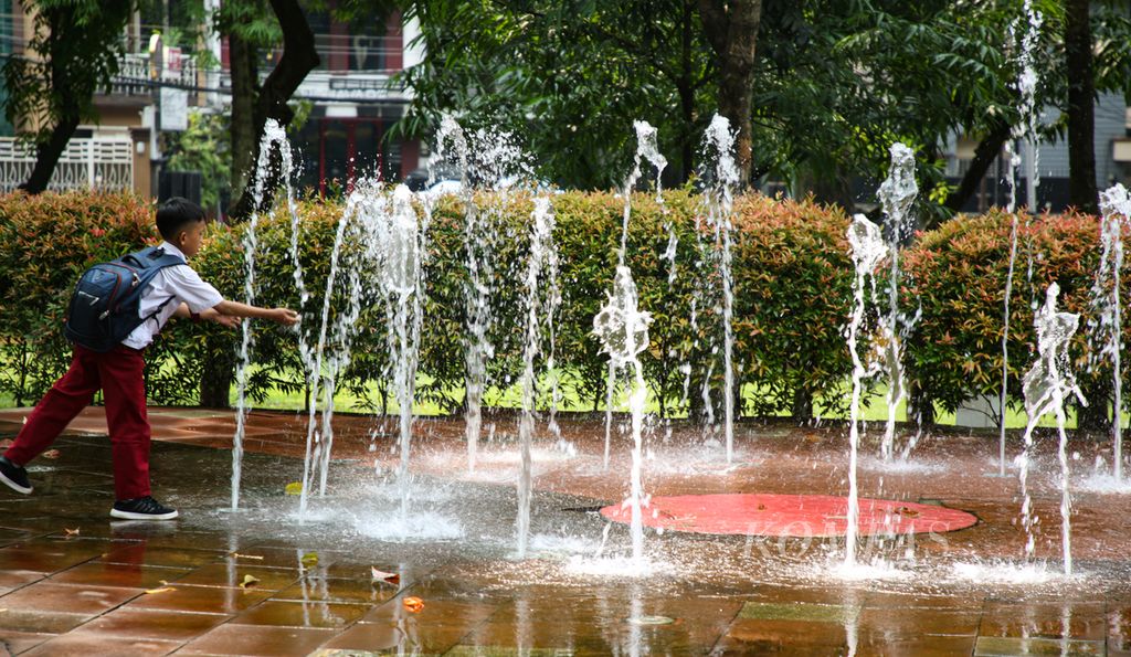 Seorang siswa sekolah dasar membasuh tangannya di air mancur di Taman Puring, Kebayoran Baru, Jakarta Selatan, Senin (29/5/2023). 