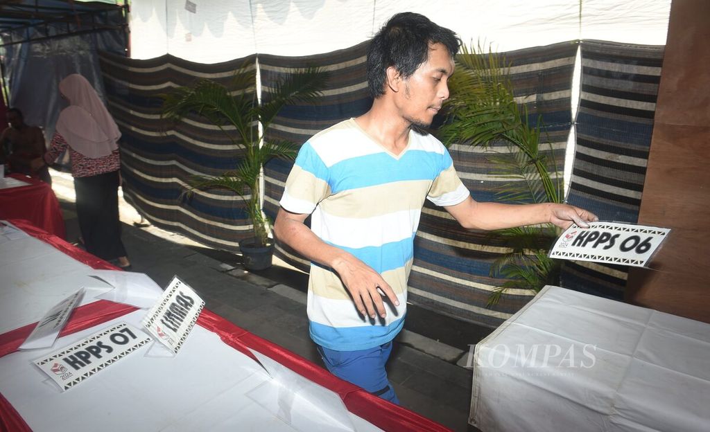 Petugas menyiapkan label panitia saat pembuatan Tempat Pemungutan Suara (TPS) 08 di Kranggan Margorejo, Wonocolo, Surabaya, Selasa (13/2/2024).