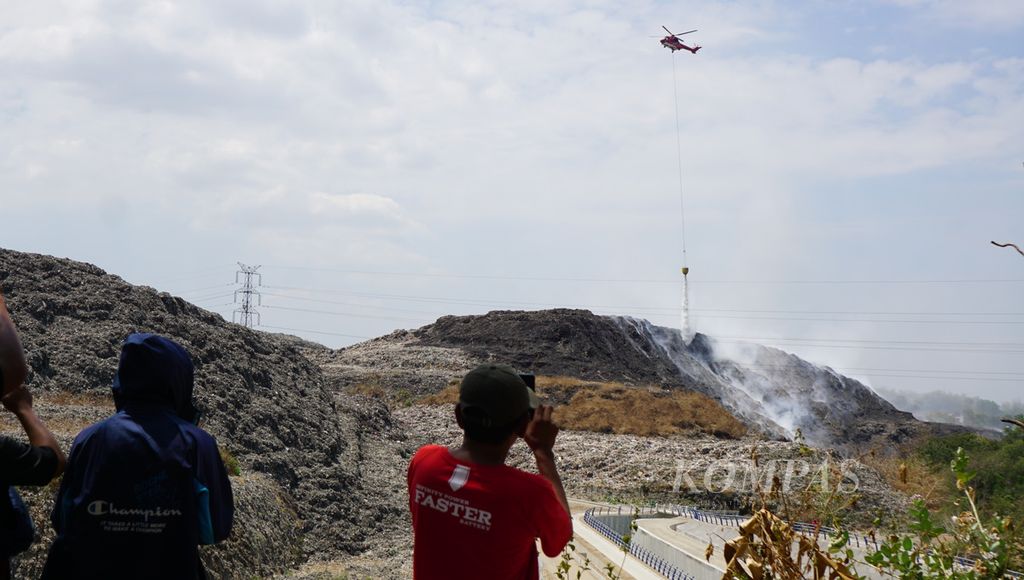Pemadaman api menggunakan metode <i>water bombing</i> dilakukan di Tempat Akhir Putri Cempo, Kota Surakarta, Jawa Tengah, Selasa (19/9/2023). Titik api masih ditemukan sejak kebakaran terjadi pada Sabtu (16/9/2023). Pemilihan metode itu karena ada titik api yang sulit dijangkau oleh petugas pemadam kebakaran.