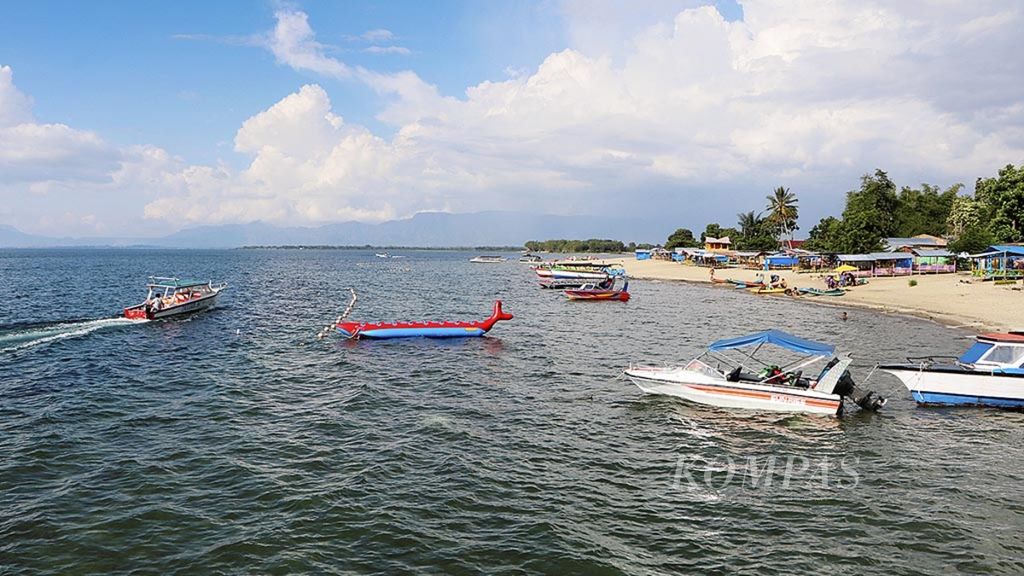 Wisatawan menikmati keindahan Danau Toba di Pantai Pasir Putih Lumban Bulbul, Kecamatan Balige, Kabupaten Toba Samosir, Sumatera Utara, Jumat (9/6/2017).