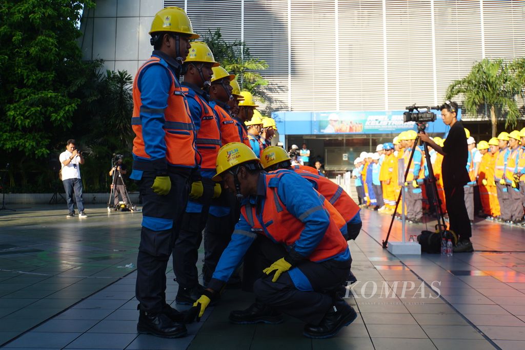 Para karyawan PT Perusahan Listrik Negara saling mengecek kelengkapan alat keselamatan kerja dalam apel siaga kelistrikan di kantor pusat PT PLN di Jakarta, Rabu (20/12/2023).