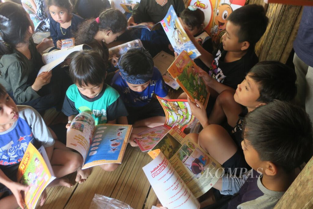 Anak-anak suku Baduy Luar antusias membaca majalah komik sains Kuark yang dibagikan di acara #BerbagiTerang Goes To Baduy di Desa Kadujangkung, Desa Kanekes, Kabupaten Lebak, Banten, Sabtu (8/8/2019). Namun, kemampuan membaca anak-anak suku Baduy Luar belum merata.