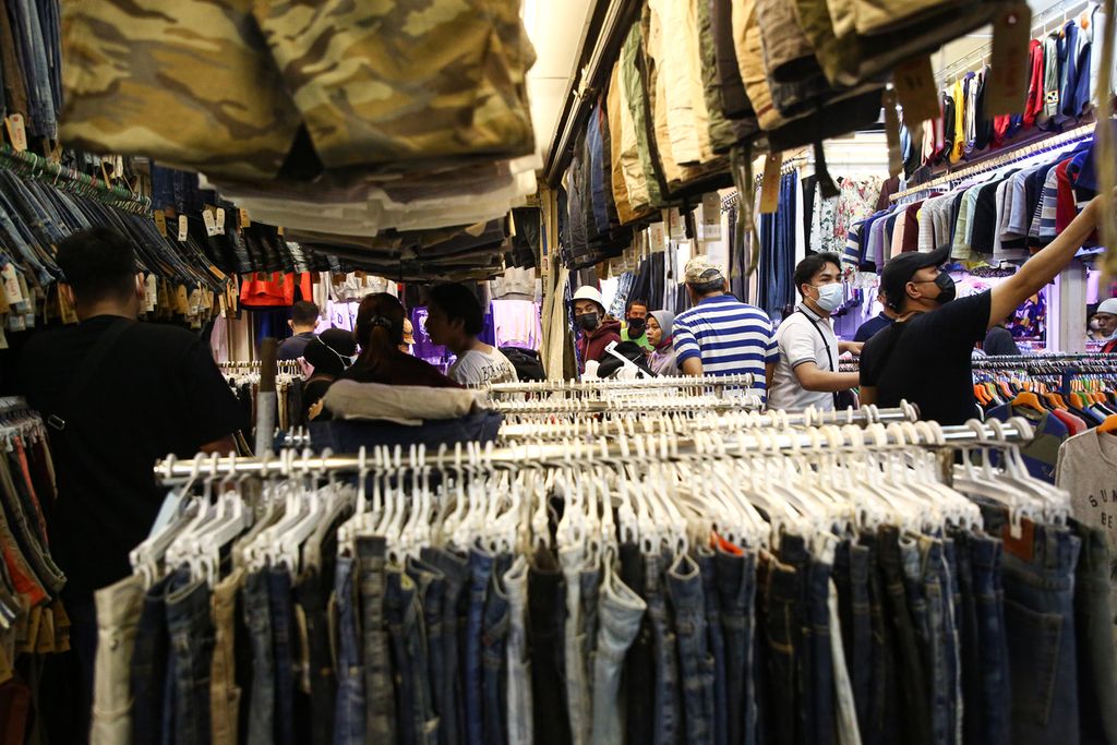 Pengunjung berburu pakaian seken impor atau<i> thrifting </i>di Pasar Senen Blok 3, Jakarta Pusat, Selasa (19/10/2021)<i>. Thrifting</i> populer sejak beberapa tahun terakhir. Keberadaan media sosial turut memopulerkan penjualan pakaian seken impor merek-merek ternama yang banyak digandrungi kalangan remaja.