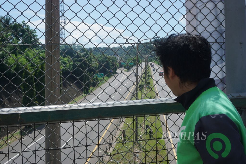 Ade Suhendri (34) melihat situasi jalan tol menuju Pelabuhan Merak, Cilegon, Banten, yang lengang pada Senin (8/4/2024).