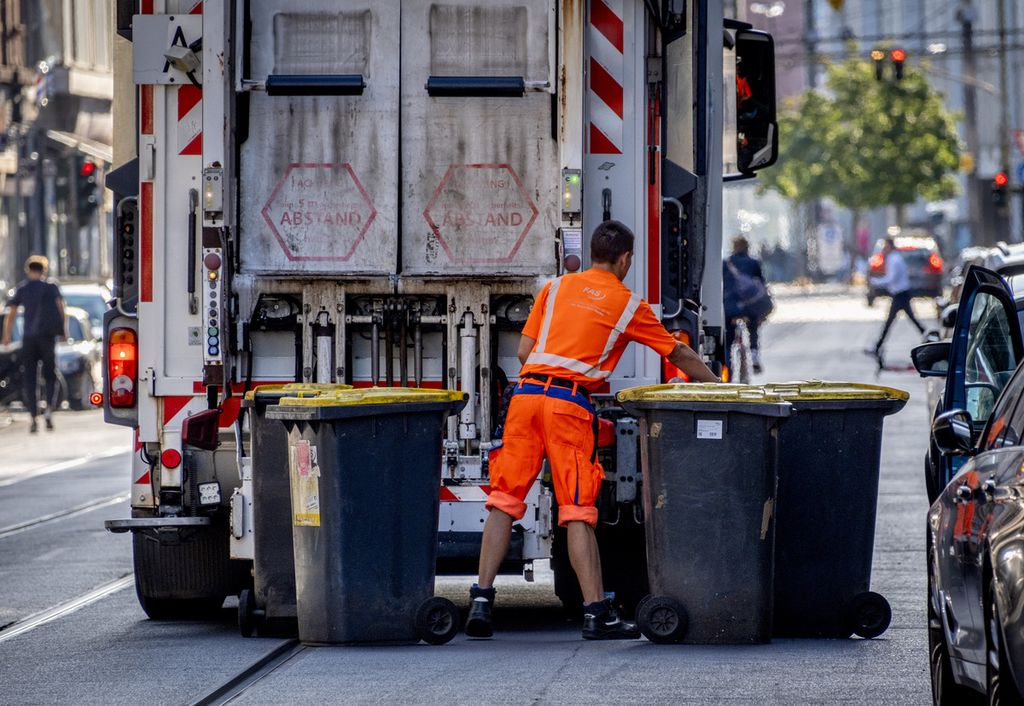 Seorang pekerja sampah mengosongkan tempat sampah di Frankfurt, Jerman, pada 19 Juli 2023.  