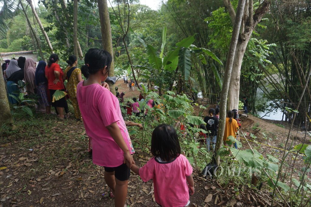 Warga menonton tim Kepolisian Resor Kota Banyumas menggali tanah kosong untuk mencari kerangka bayi yang diduga menjadi korban aborsi, di Purwokerto, Banyumas, Jawa Tengah, Kamis (22/6/2023).