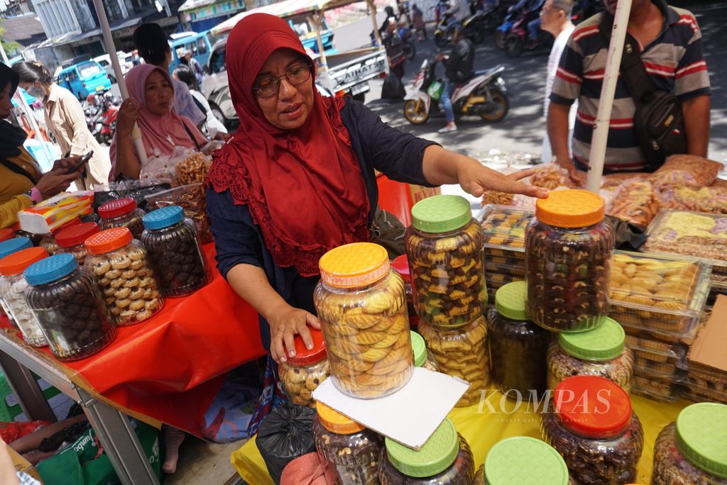 Erlin Laginta (40), pedagang kue kering asal Gorontalo, membuka lapak kue kering di daerah Wenang dekat Pelabuhan Manado, Sulawesi Utara, Senin (19/12/2022). Selama lima tahun terakhir, ia selalu menghabiskan bulan Desember di Manado untuk menjajakan kukis.