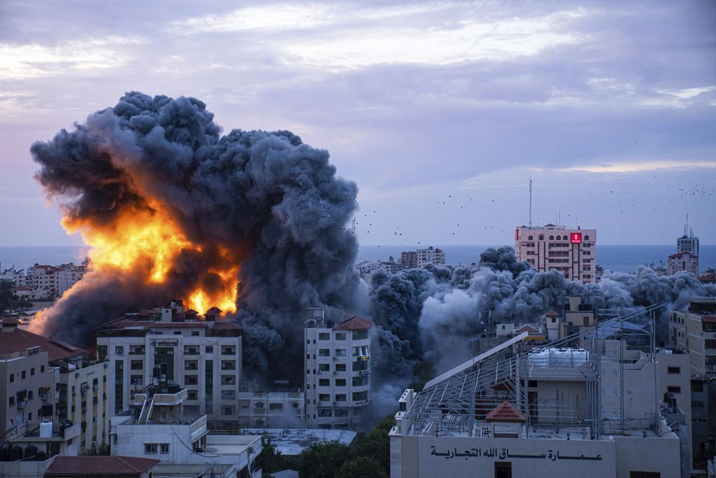 Api dan asap tebal membubung ke angkasa menyusul gempuran udara Israel di Gaza City, Sabtu (7/10/2023).  