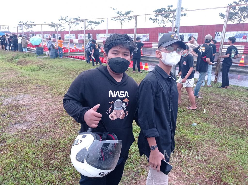 Rizki Herisaputra (14) dan Nadif Variel (14) menyaksikan Fastron Enduro Street Race Polda Metro Jaya-BSD di Jalan Gipti BSD Grand Boulevard, Kabupaten Tangerang, Jumat (22/4/2022).