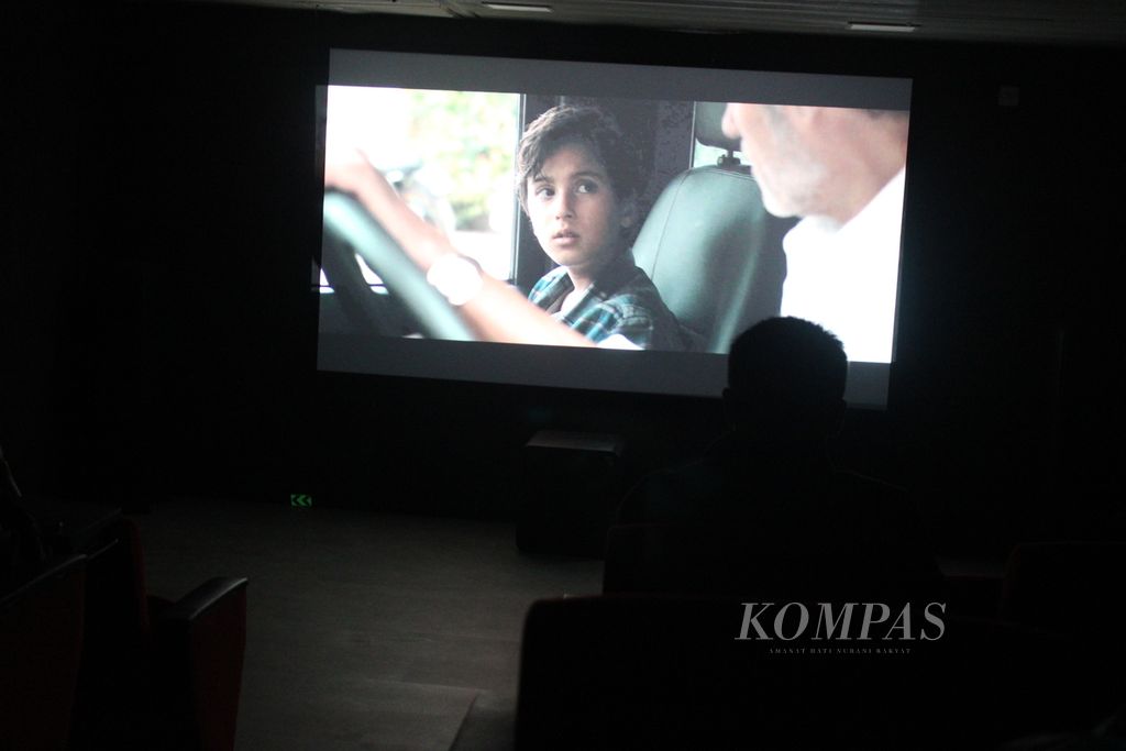 Penumpang menonton film di bioskop KM Kelud ketika berlayar dari Medan, Sumatera Utara, menuju Batam, Kepulauan Riau, Selasa (27/2/2024) malam. 
