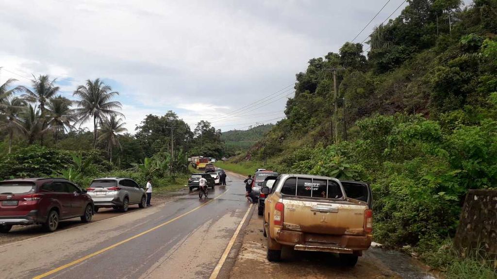 Jalan trans-Sulawesi lumpuh akibat banjir bercampur lumpur setinggi lebih dari 1 meter yang menerjang wilayah Konawe Utara, Sulawesi Tenggara, Jumat (3/5/2024). Kendaraan antre di lokasi yang lebih tinggi dan tidak terendam banjir untuk menunggu air surut. Jalan itu satu-satunya penghubung Sultra dan Sulteng.