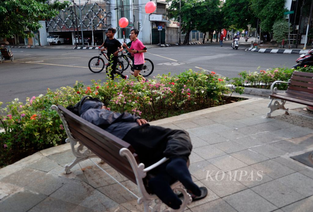 Peserta melintasi warga yang tidur di kursi taman saat mengikuti lari sekaligus peluncuran penyelenggaraan Semarang 10K di Khas Hotel, Kota Semarang, Jawa Tengah, Minggu (16/10/2022).