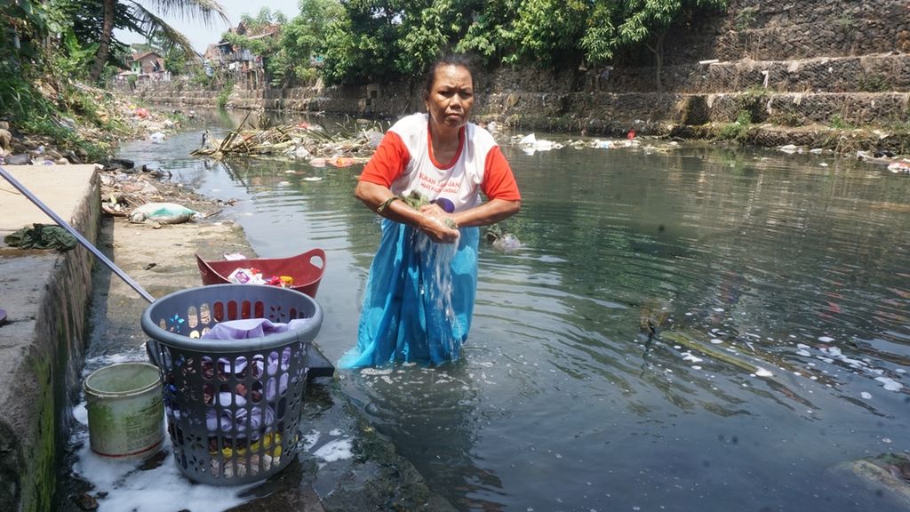 Warga Kelurahan Gedung Pakuan, Kecamatan Teluk Betung Selatan, Kota Bandar Lampung, memanfaatkan sungai yang kotor dan penuh sampah untuk mencuci, Jumat (23/8/2019).