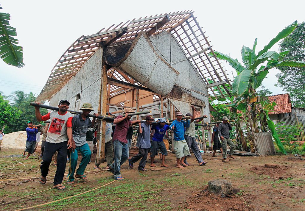 Puluhan warga Desa Sri Rejosari, Kabupaten Lampung Timur, Lampung, bergotong royong memindahkan rumah milik salah satu warga dari satu tempat ke tempat lain pada 21 Desember 2014.