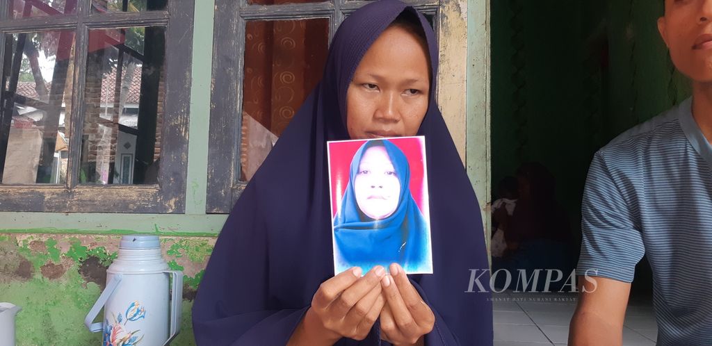 Sima menunjukkan foto kakaknya, Rasni, korban pembunuhan, di Desa Cangkoak, Kecamatan Dukupuntang, Kabupaten Cirebon, Jawa Barat, Senin (27/11/2023). Korban diduga menjadi korban pembunuhan oleh mantan suami sirinya.