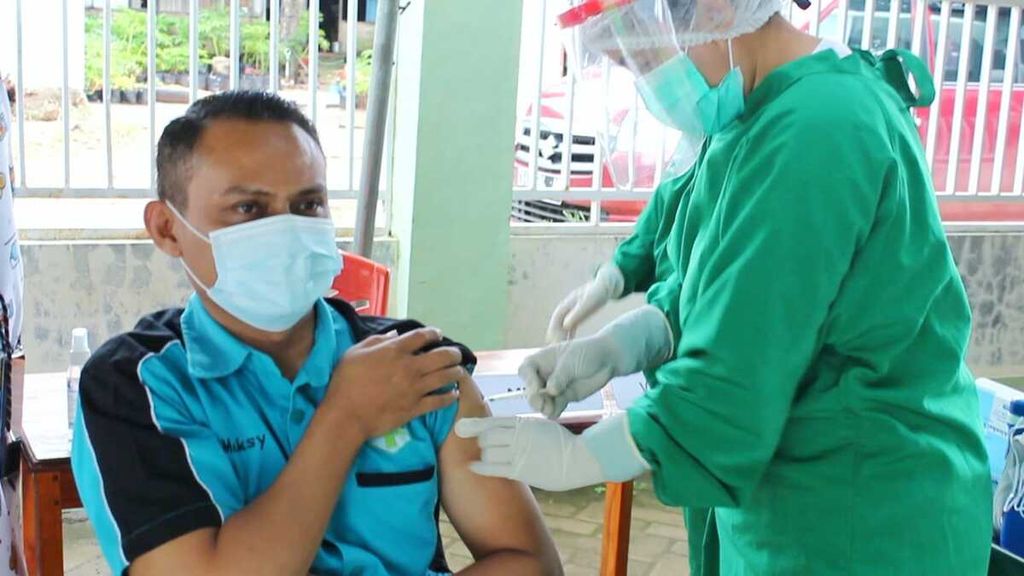 Alfons (36), tenaga kesehatan di Puskesmas Bakunase, Kota Kupang, menerima vaksin, Selasa (19/1/2021). 