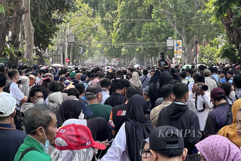 Warga di kawasan Jalan Pejanggik, Kota Mataram, Nusa Tenggara Barat,  menyaksikan parade para pebalap  Moto2 dan Moto3 , Rabu (11/10/2023) siang.