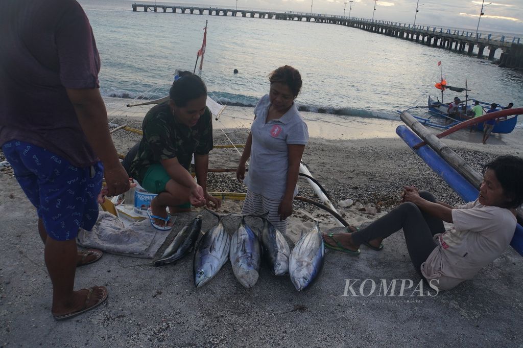 Warga Miangas, Kepulauan Talaud, Sulawesi Utara, berkumpul untuk memilih ikan cakalang dan salmon yang dijual nelayan, Kamis (5/3/2020). Seekor cakalang dijual seharga Rp 100.000.