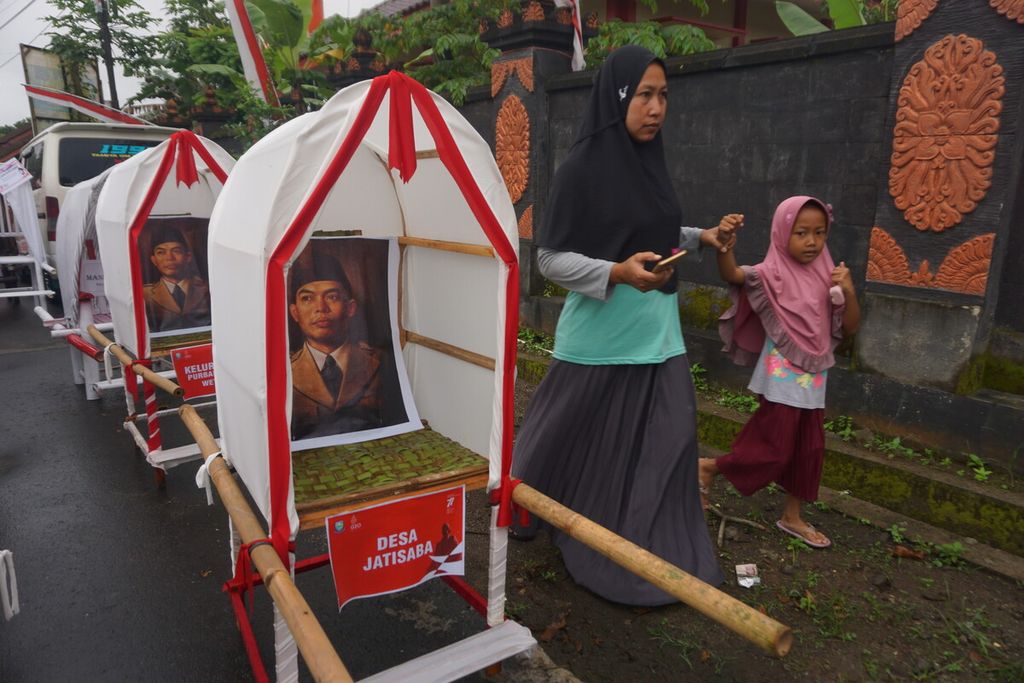 Warga melintas di sekitar replika tandu Jenderal Besar Soedirman di Desa Bantarbarang, Kecamatan Rembang, Kabupaten Purbalingga, Jawa Tengah, Rabu (31/8/2022).