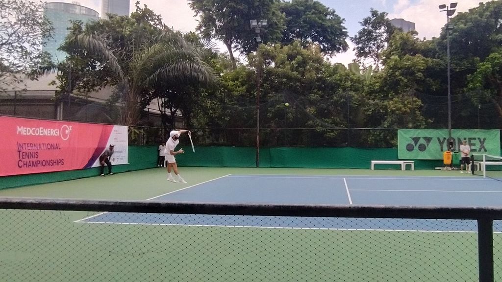 Petenis Perancis Arthur Weber tengah melakukan servis yang ditujukan pada petenis Jepang Renta Tokuda pada pertandingan semifinal Turnamen Tenis Internasional Medco Energi 2022, Sabtu (29/10/2022).