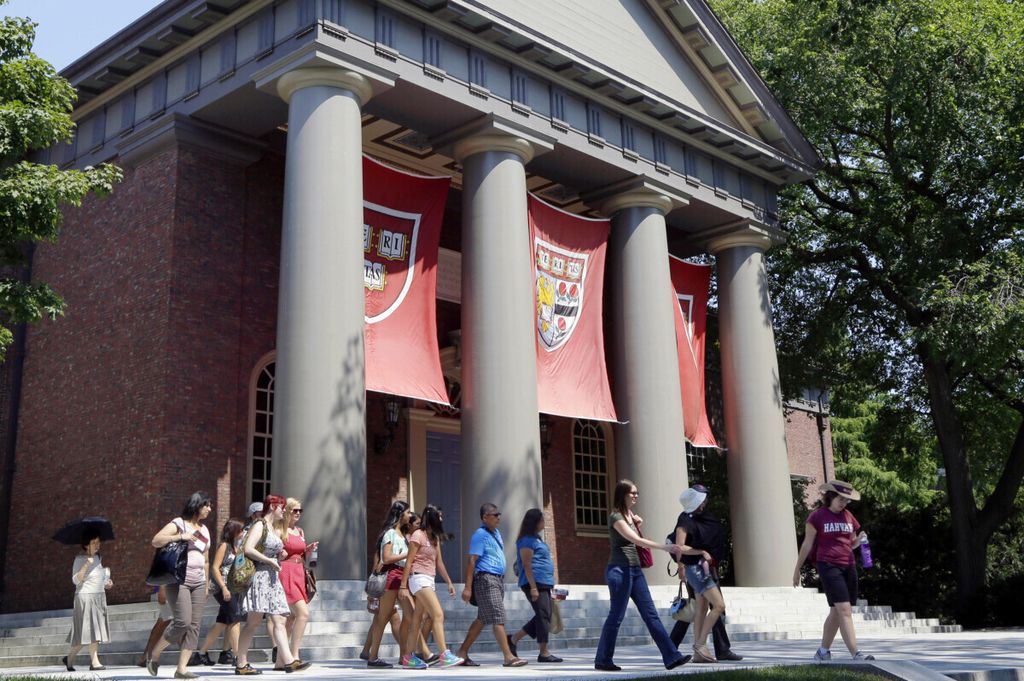 Foto tanggal 30 Agustus 2012 ini memperlihatkan rombongan tur melewati kompleks kampus Universitas Harvard di Cambridge, Massachusetts, AS. 
