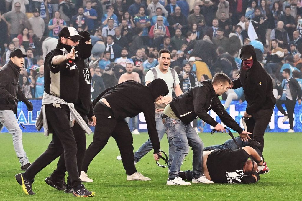 Fans Udinese mengeroyok fans Napoli (bawah) saat penonton menyerbu lapangan pada akhir pertandingan Seri A Italia antara Udinese dan Napoli yang berakhir imbang 1-1.