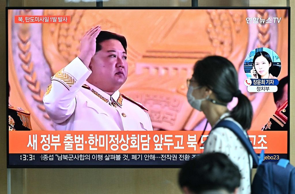 Seorang warga melintas di depan televisi yang menayangkan gambar Pemimpin Korea Utara, Kim Jong Un, di sebuah stasiun di Seoul pada Rabu (4/5/2022).