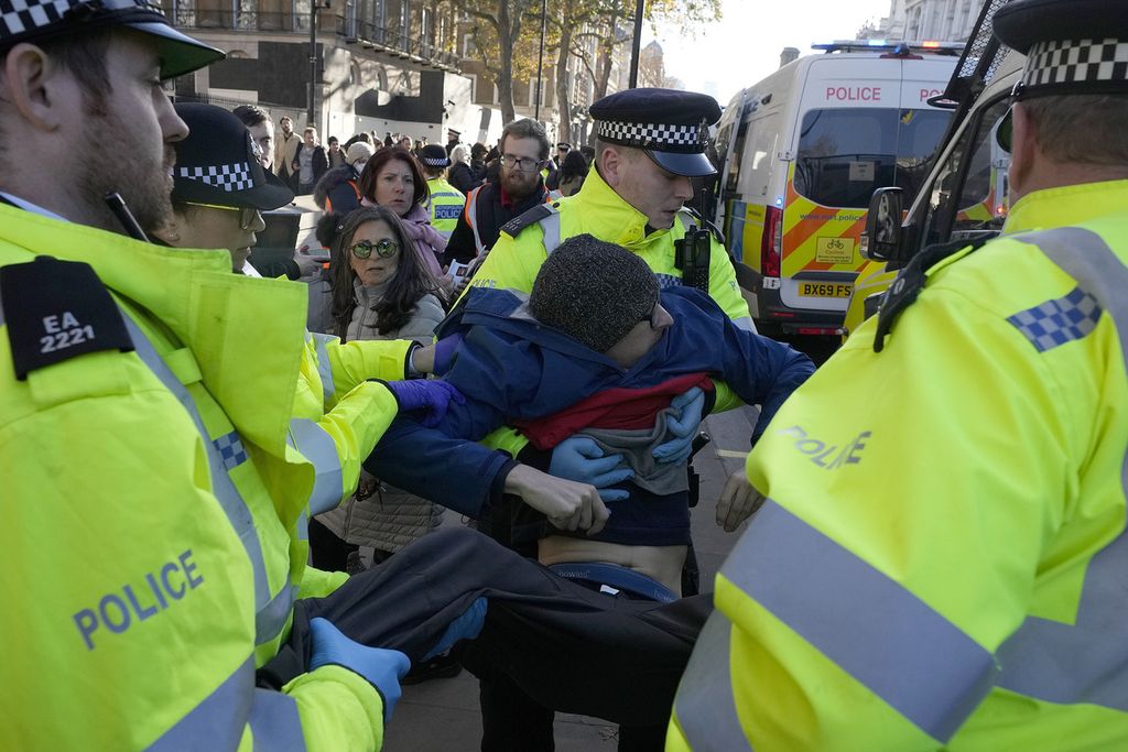 Polisi menangkap pengunjuk rasa kelompok aktivis iklim Just Stop Oil di luar Downing Street di London, pada 23 November 2023. Inggris adalah salah satu negara demokrasi tertua di dunia, tetapi beberapa pihak khawatir hak-hak dan kebebasan penting kini terancam karena pembatasan protes yang diberlakukan pemerintah konservatif. 