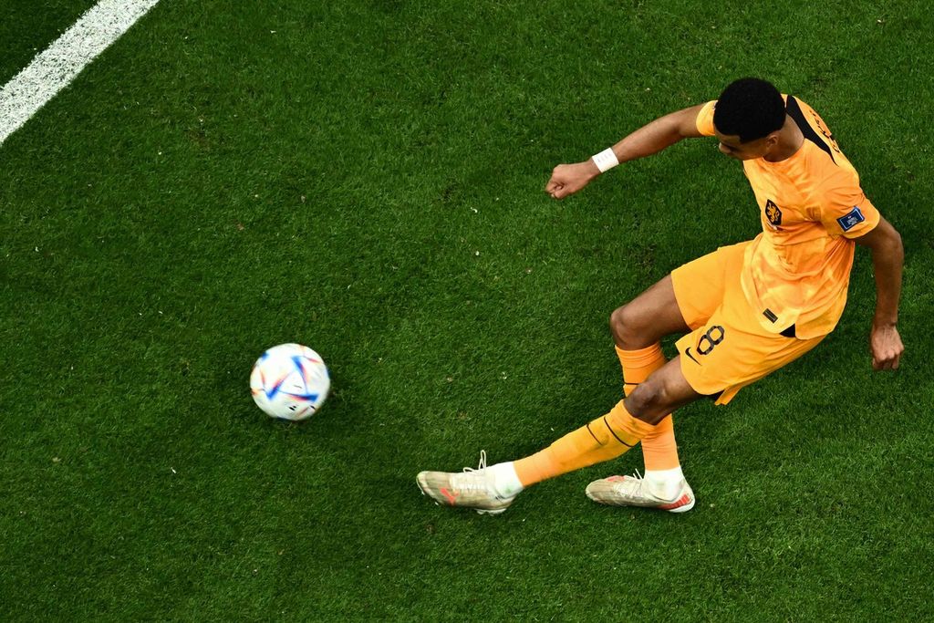 Penyerang Belanda, Cody Gakpo, menendang bola pada laga melawan Qatar dalam penyisihan Grup A Piala Dunia  Qatar di Stadion Al-Bayt, Al Khor, Selasa (29/11/2022) malam. Gakpo menyecetak satu gol dalam laga yang dimenangi Belanda, 2-0, ini.