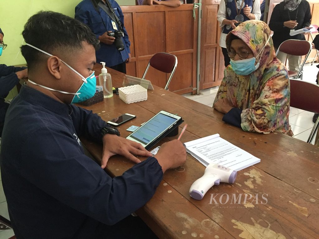 Tenaga kesehatan mewawancarai seorang warga terkait ada atau tidaknya gejala Covid-19 dan tuberkulosis dalam kegiatan penapisan tuberkulosis yang digelar tim Proyek Zero TB di Balai Desa Giri Purwo, Kabupaten Kulon Progo, Selasa (29/3/2022).