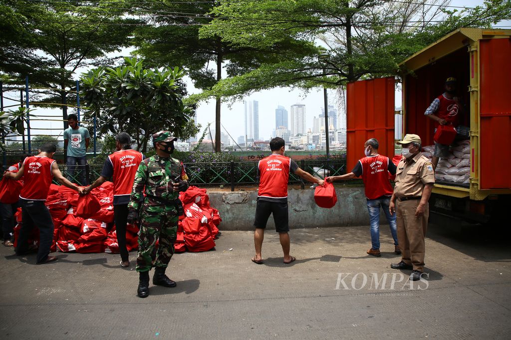 Personel TNI mengawal penurunan paket bantuan sosial Covid-19 presiden yang disalurkan melalui Kementerian Sosial di Kelurahan Petamburan, Tanah Abang, Jakarta Pusat, Selasa (29/9/2020). 