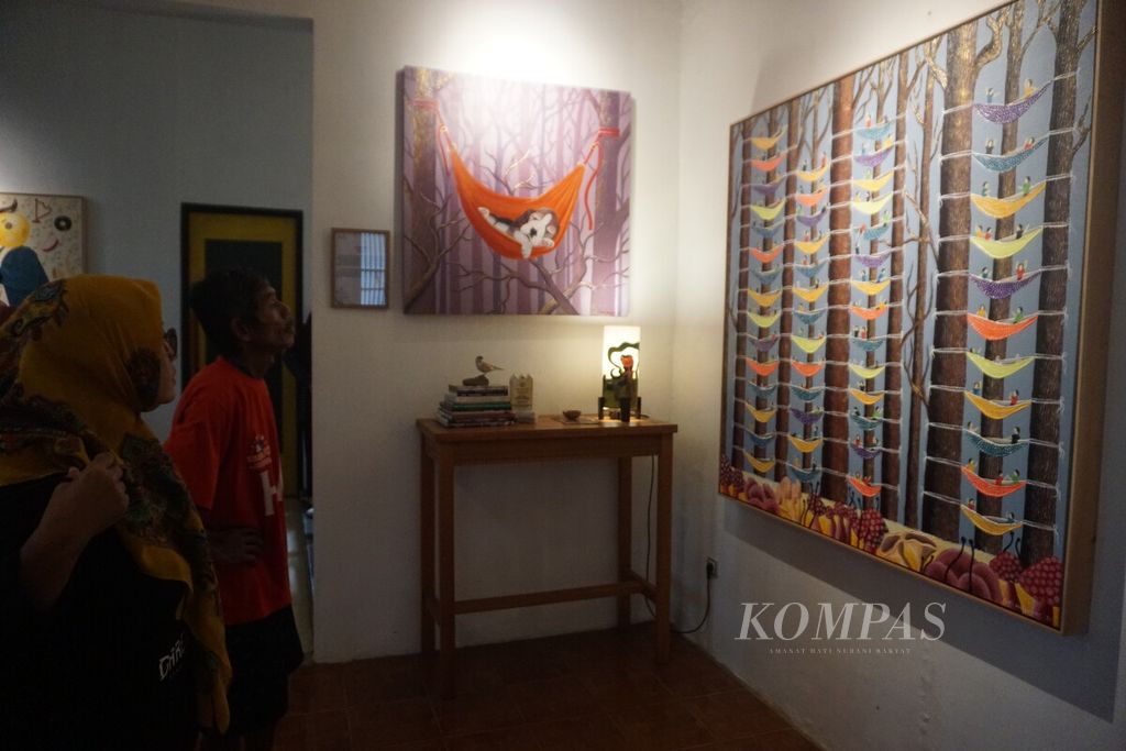 Pengunjung melihat pameran lukisan The Tree of Life karya Budi Setiyawan di Kie Art Project Gallery, Desa Kartun Sidareja, Purbalingga, Jawa Tengah, Minggu (16/7/2023).