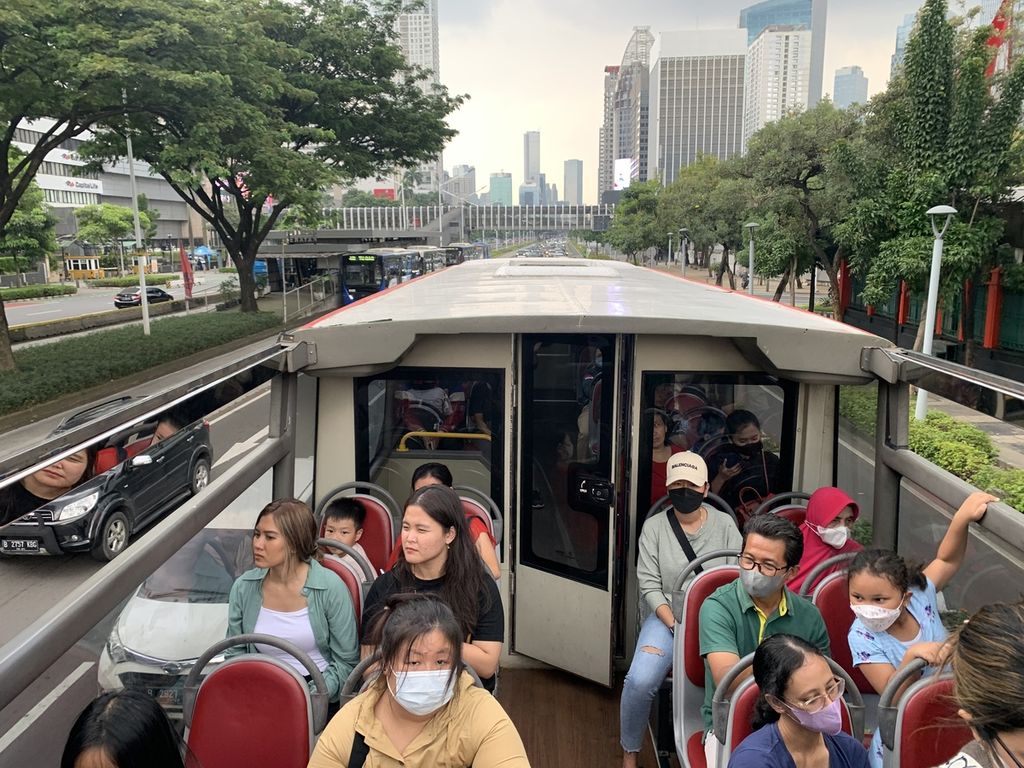 Masyarakat menikmati akhir pekan sambil menunggu waktu berbuka puasa dengan menaiki bus wisata Transjakarta, di Jakarta, Sabtu (25/3/2023).