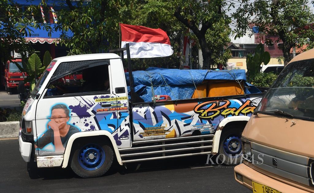 Sebuah mobil bak terbuka membawa bendera Merah Putih saat melintasi Jalan Kenjeran, Kota Surabaya, Jawa Timur, Kamis (4/8/2022). Kemeriahan jelang peringatan HUT Ke-77 Kemerdekaan RI mulai terlihat di banyak tempat. 