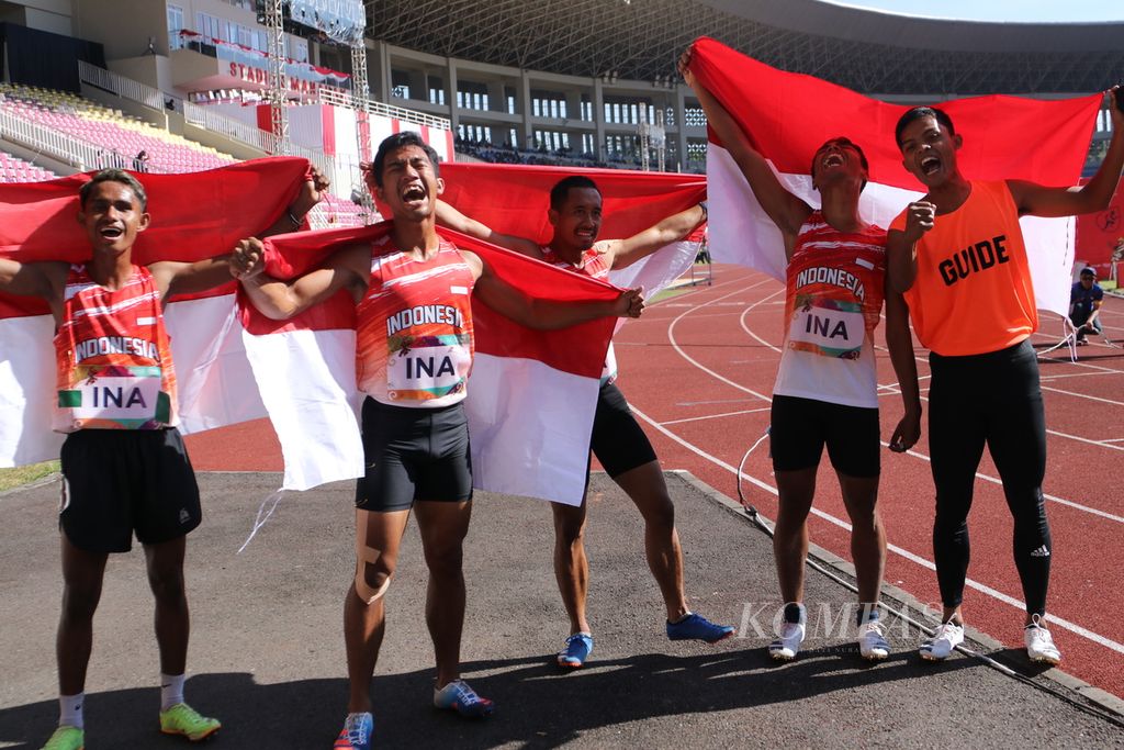 Dari kiri ke kanan sprinter Petrus Alupan (T12) , Eko Saputra (T12), Muammar Habibila (T13), Ruli Al Kahfi (T11) bersama pemandu Sika Buddin merayakan medali emas yang mereka raih dalam nomor estafet 4 x 100 meter T11-13 ASEAN Para Games Solo 2022 di Stadion Manahan, Surakarta, Jumat (5/8/2022). Mereka mencetak waktu 44,97 detik.