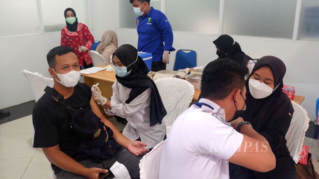 Petugas kesehatan menyuntikkan vaksin dosis ketiga atau penguat (<i>booster</i>) kepada warga di Terminal Tipe A Gambut Barakat, Kabupaten Banjar, Kalimantan Selatan, Selasa (15/3/2022).