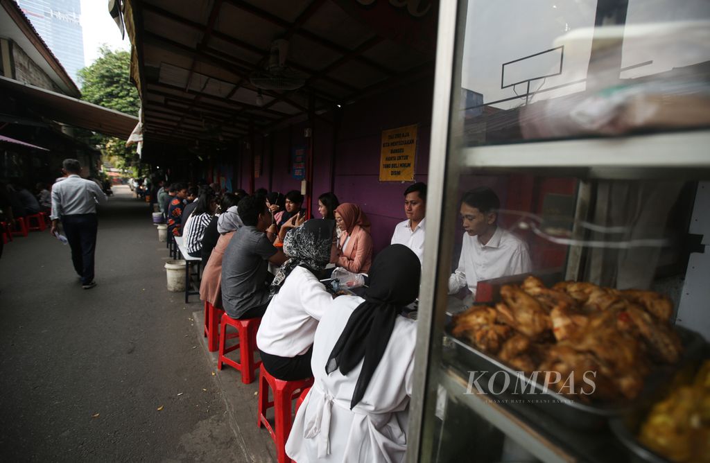 Pekerja menikmati santap sianng. dari pedagang makanan kaki lima di kawasan Setiabudi, Jakarta Selatan,Senin (20/5/2024). Jumlah pekerja informal cenderung meningkat.