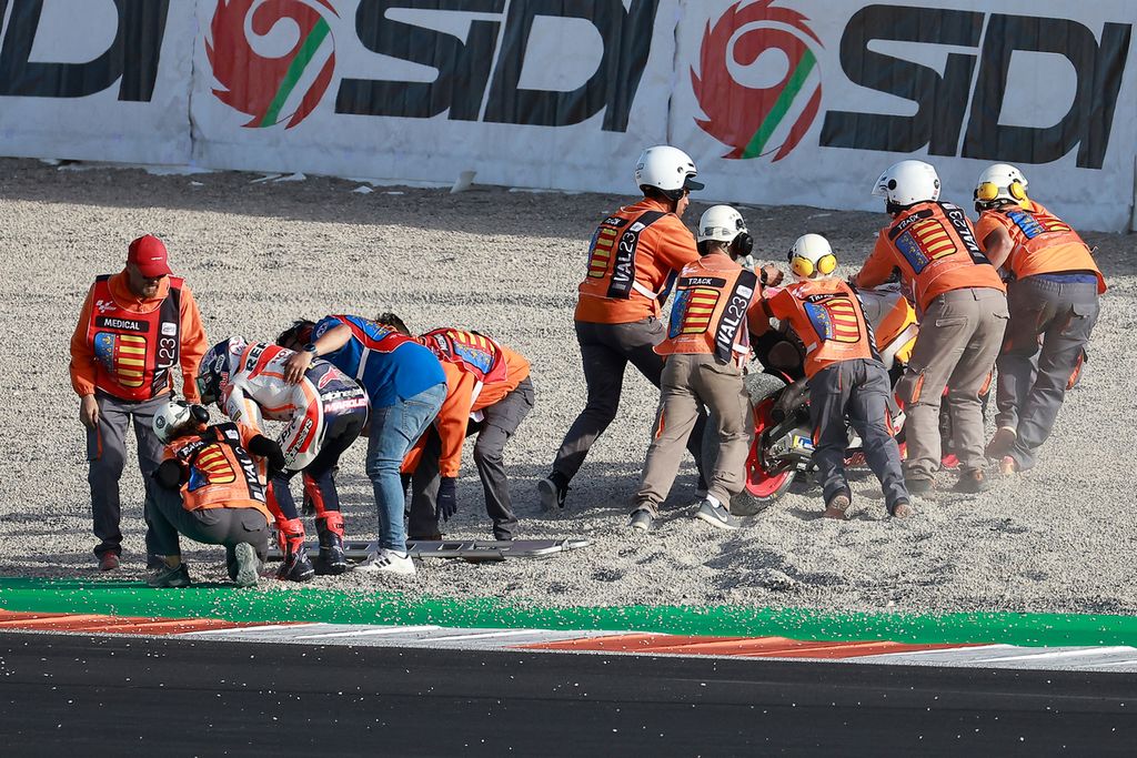 Pebalap Repsol Honda, Marc Marquez, dibantu  tim medis setelah terjatuh saat Grand Prix MotoGP Seri Valencia di Sirkuit Ricardo Tormo, Spanyol, Minggu (26/11/2023). 