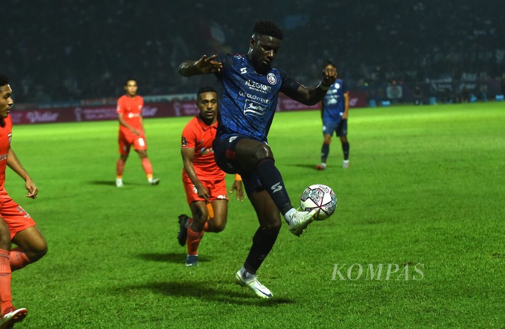 Pemain Arema FC, Abel Camara, membawa bola di bawah bayangan pemain Borneo FC Samarinda dalam laga pertama final Piala Presiden 2022 di Stadion Kanjuruhan, Kabupaten Malang, Kamis (14/7/2022). Arema FC menang, 1-0.