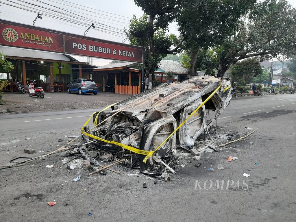Sisa mobil polisi yang dibakar massa di gerbang Stadion Kanjuruhan, Kabupaten Malang, Jawa Timur, Minggu (2/10/2022).